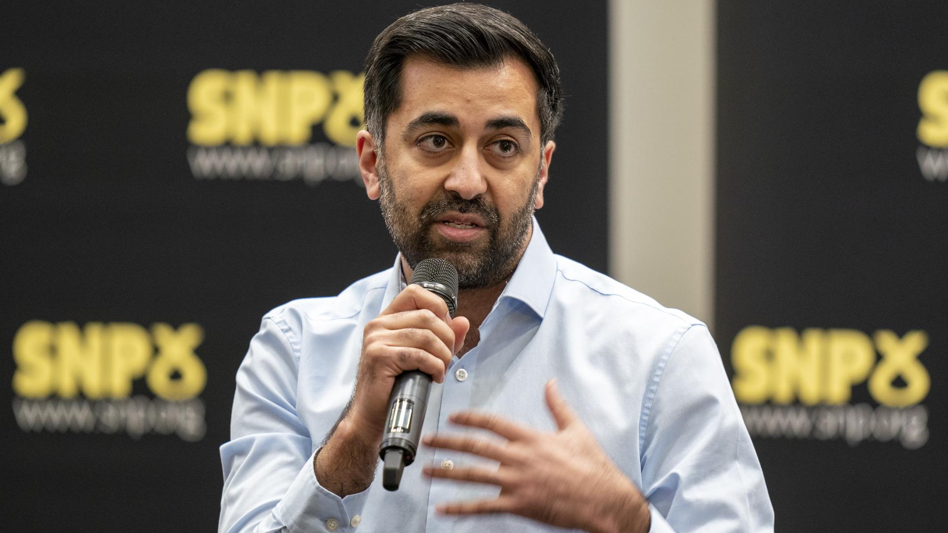Humza Yousaf nimmt an einer SNP-Führungsdebatte an der University of Strathclyde teil. Er hält ein Mikrofon in der Hand.