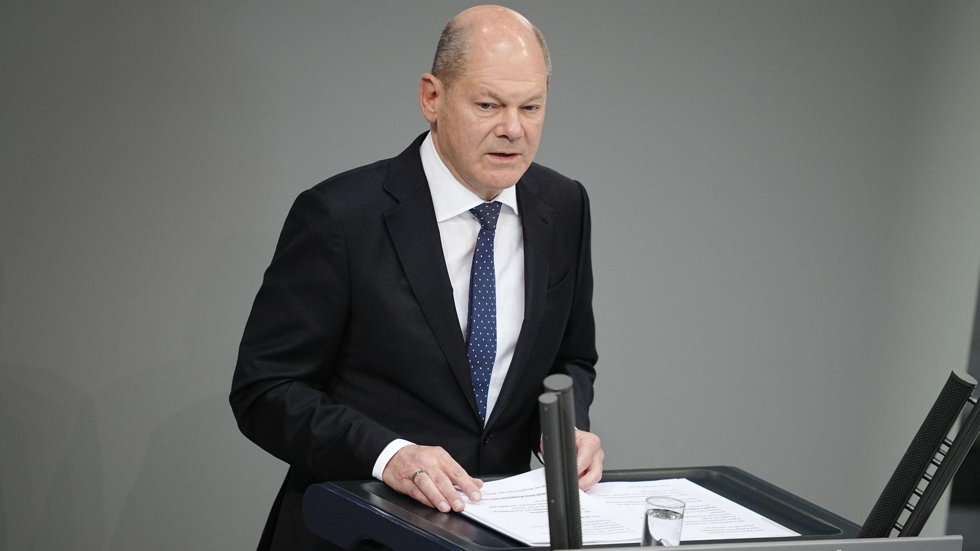 Berlin: Bundeskanzler Olaf Scholz steht im Bundestag hinter einem Rednerpult mit Mikrofonen.