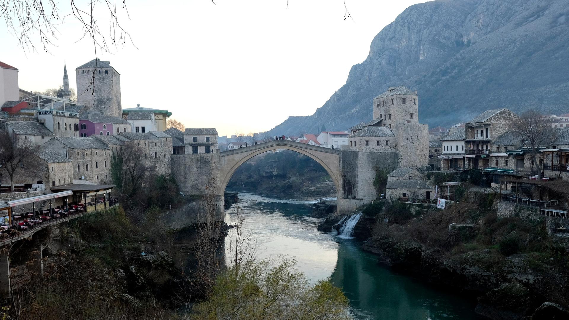 Eine Brücke führt über eine Fluss, der durch ein Tal fließt. Die Brücke verbindet Teile der Stadt Mostar. Eine Brücke führt über eine Fluss, der durch ein Tal fließt. Die Brücke verbindet Teile der Stadt Mostar.