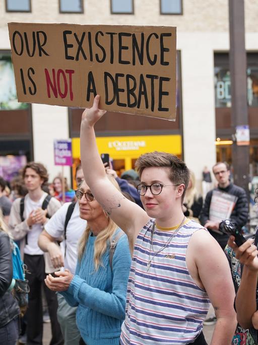 Die LGBTQ-Community protestiert gegen die Rede der Philosophin Kathleen Stock. Die Menschen halten Schilder hoch.