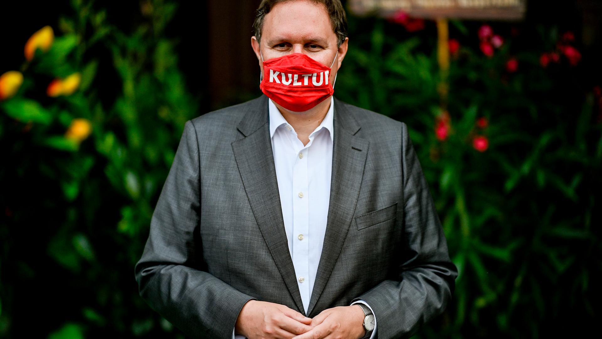 Carsten Brosda trägt einen roten Mundnasenschutz mit der Aufschrift "Kultur".