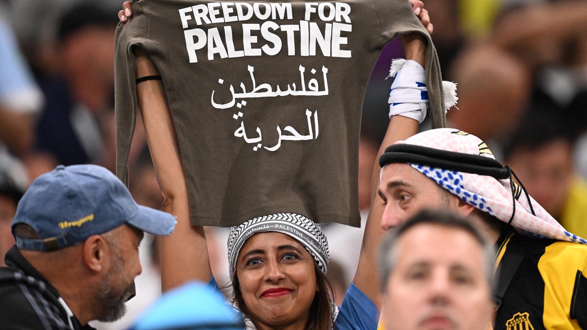 Anhängerin mit "Pro-Palastinä"-Shirt im Stadion bei der Fußball-Weltmeisterschaft in Katar Anhängerin mit "Pro-Palastinä"-Shirt im Stadion bei der Fußball-Weltmeisterschaft in Katar