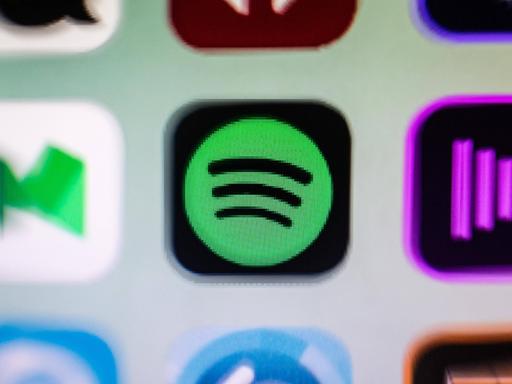 Das Bild zeigt einen kleinen Ausschnitt eines Smartphone-Bildschirms, auf dem drei App-Icons zu sehen sind. Die mittler App ist das Logo von Spotify.
