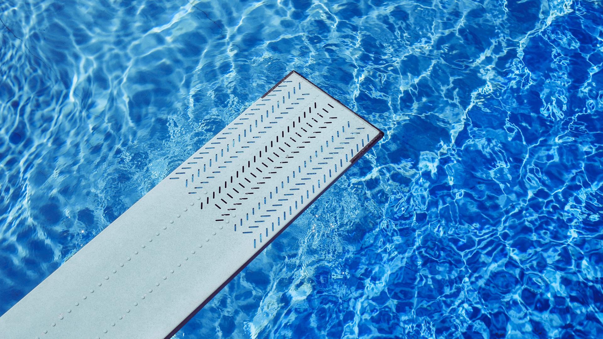 Zu sehen: Ein Sprungbrett über einem Schwimmbecken. Zu sehen: Ein Sprungbrett über einem Schwimmbecken.