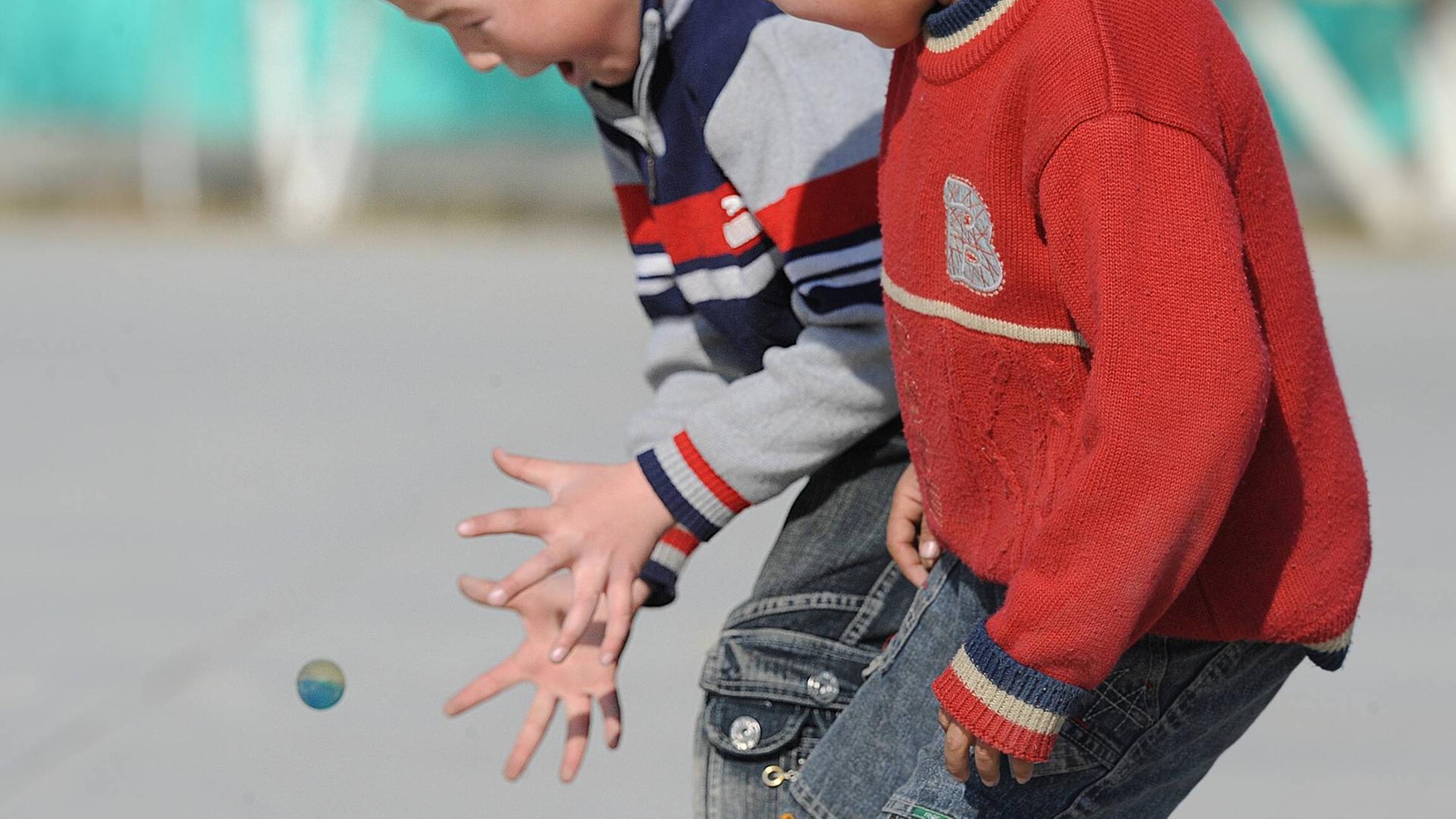 Zwei Jungs spielen mit einem Flummi. Einer versucht, ihn zu fangen. Zwei Jungs spielen mit einem Flummi. Einer versucht, ihn zu fangen.