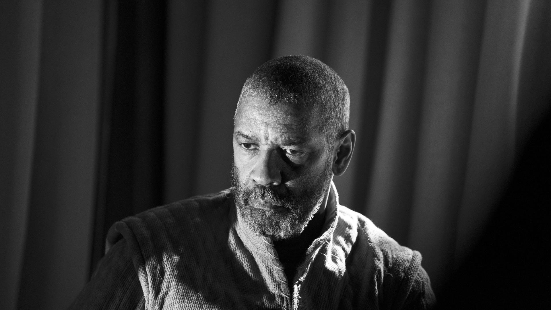 Der Schauspieler Denzel Washington spielt Macbeth, sein Gesicht ist im Halbschatten, er blickt nach links. Die Aufnahme ist in Schwarzweiß. Der Schauspieler Denzel Washington spielt Macbeth, sein Gesicht ist im Halbschatten, er blickt nach links. Die Aufnahme ist in Schwarzweiß.