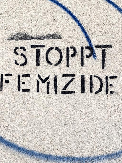 Ein Schriftzug an einer Hauswand Stoppt Femizide