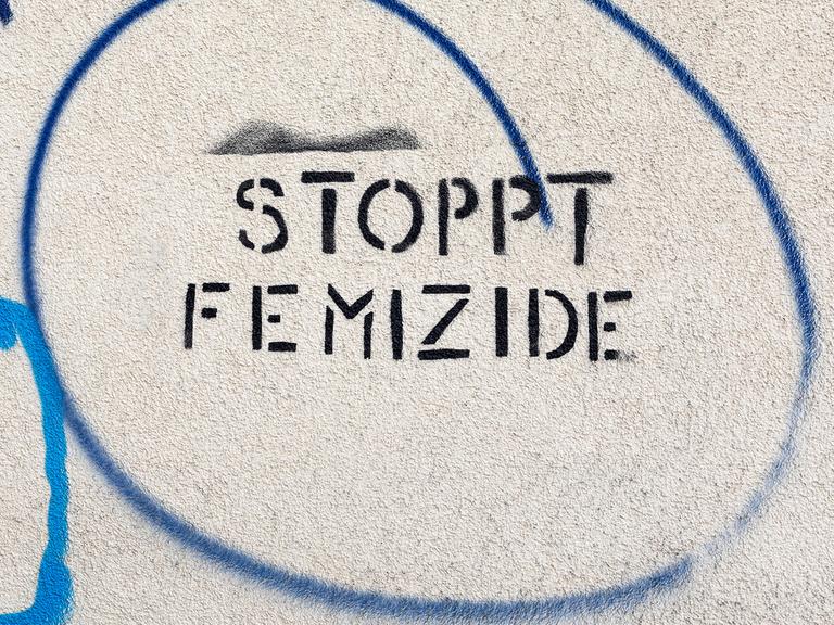 Ein Schriftzug an einer Hauswand Stoppt Femizide