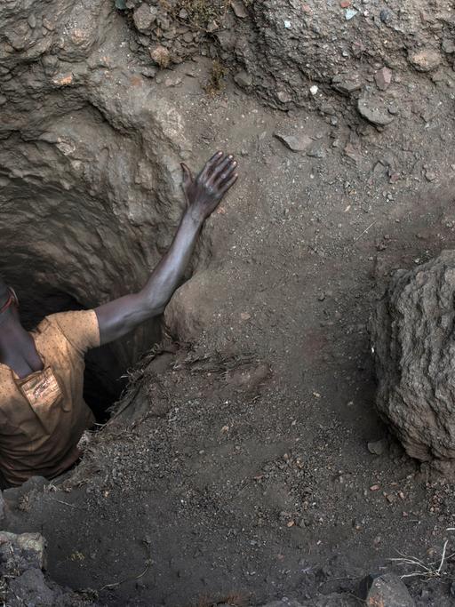 Ein Arbeiter beim Einstieg in ein kleines Loch einer Kupfer- und Kobaltmine in Kawama, Demokratische Republik Kongo.