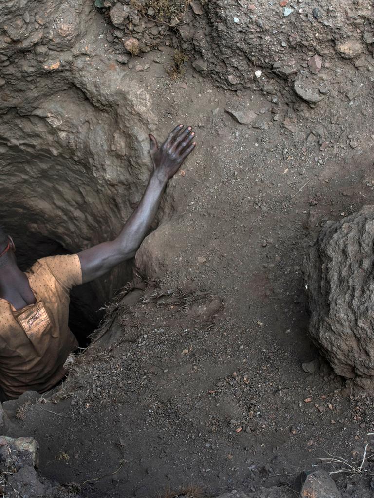Ein Arbeiter beim Einstieg in ein kleines Loch einer Kupfer- und Kobaltmine in Kawama, Demokratische Republik Kongo.