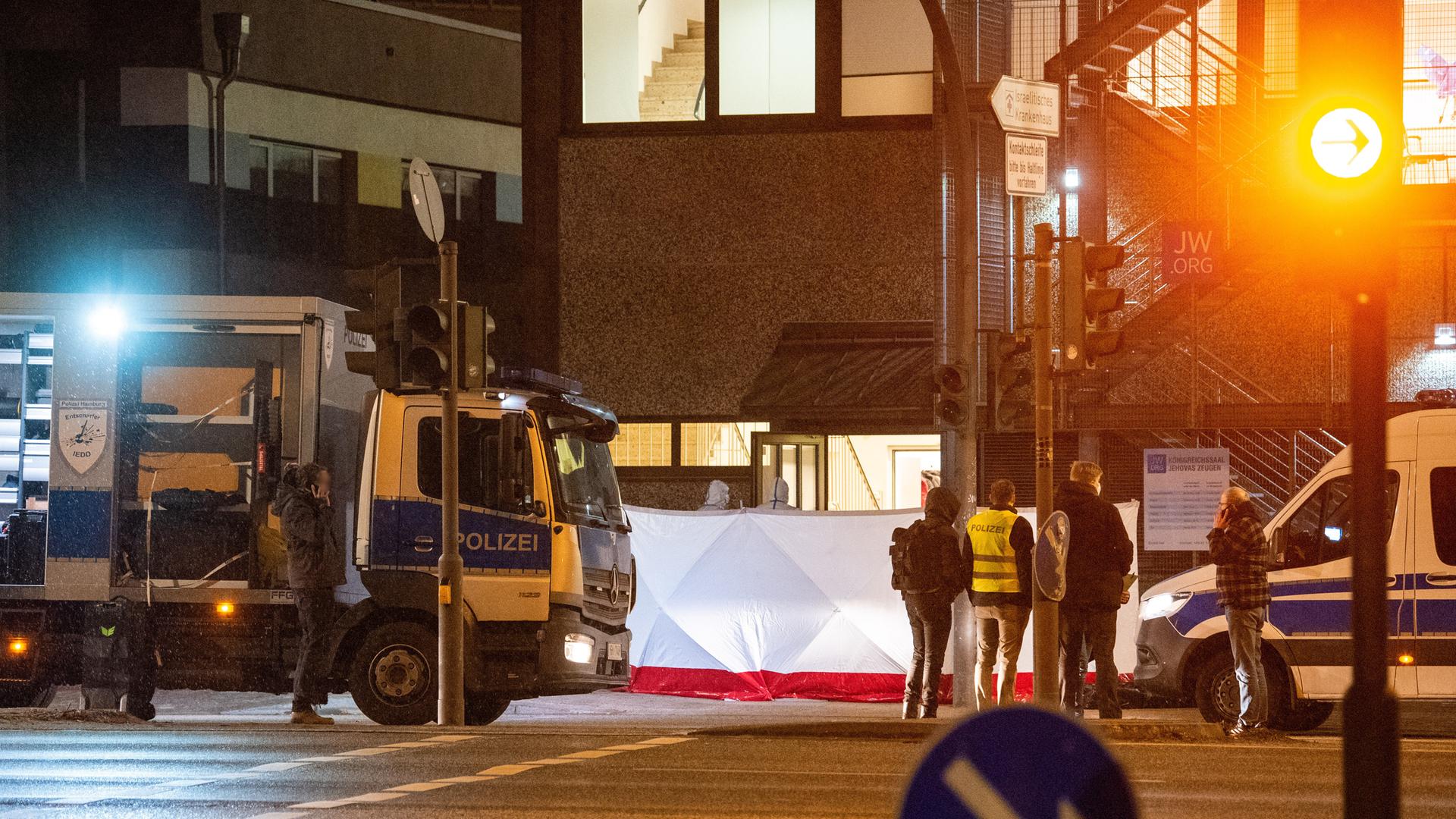 Polizisten stehen vor einem Gebäude der Zeugen Jehovas im Hamburger Stadtteil Groß Borstel. Bei Schüssen in dem Gebäude sind am Abend des 9. März 2023 mehrere Menschen getötet und einige Personen verletzt worden.