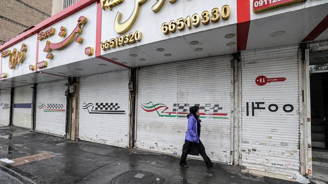 Eine Frau läuft an geschlossenen Läden in der iranischen Hauptstadt Teheran vorbei.