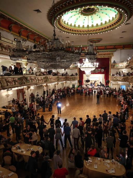 Viele Menschen bilden in der Grand Prospect Hall in New York, USA, einen Tanzkreis.