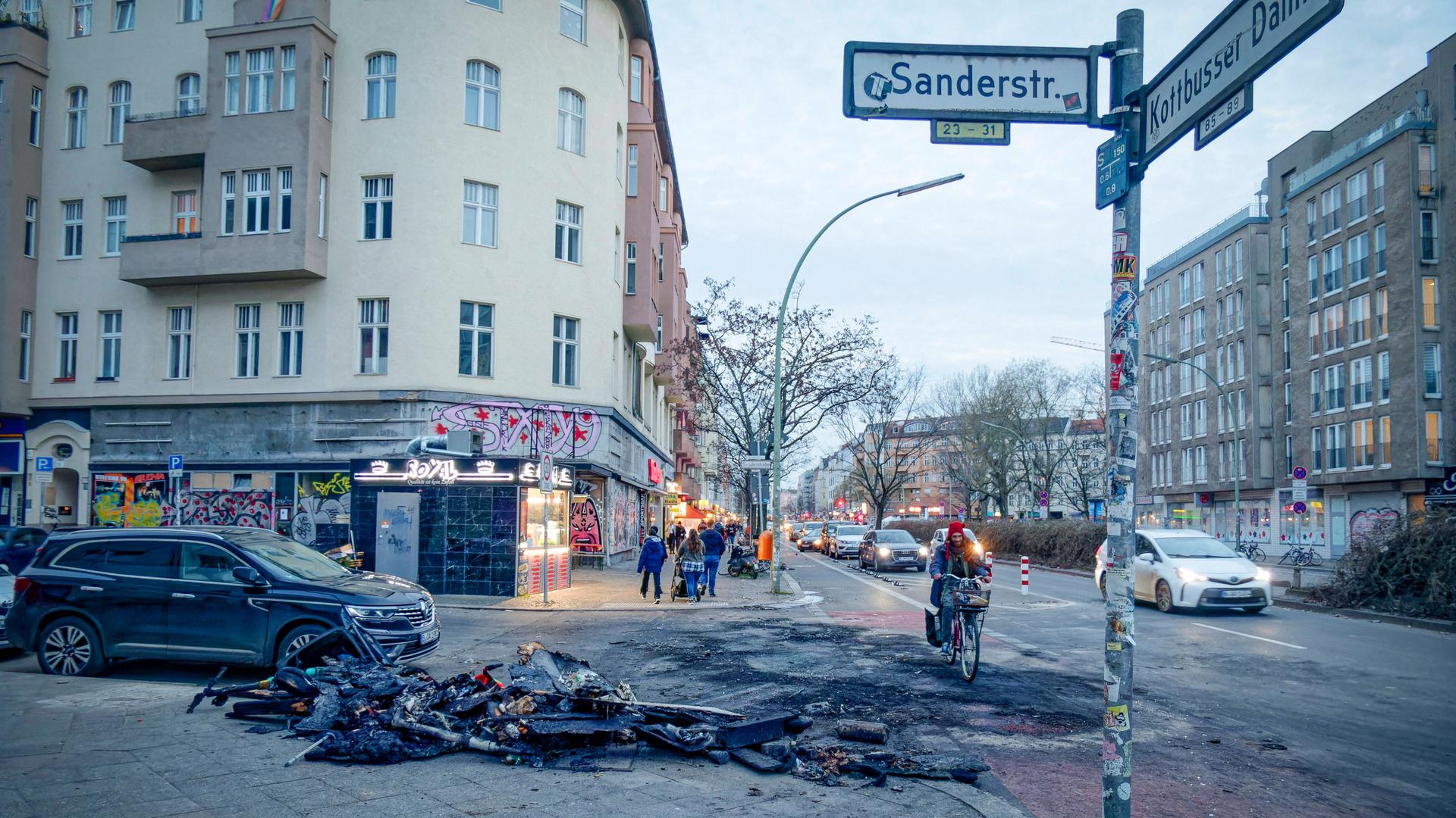 Überreste von verbrannten Mülltonnen und E-Scootern nach Randale in der Silvesternacht Sanderstrasse Ecke Kottbusser Damm in Neukölln.