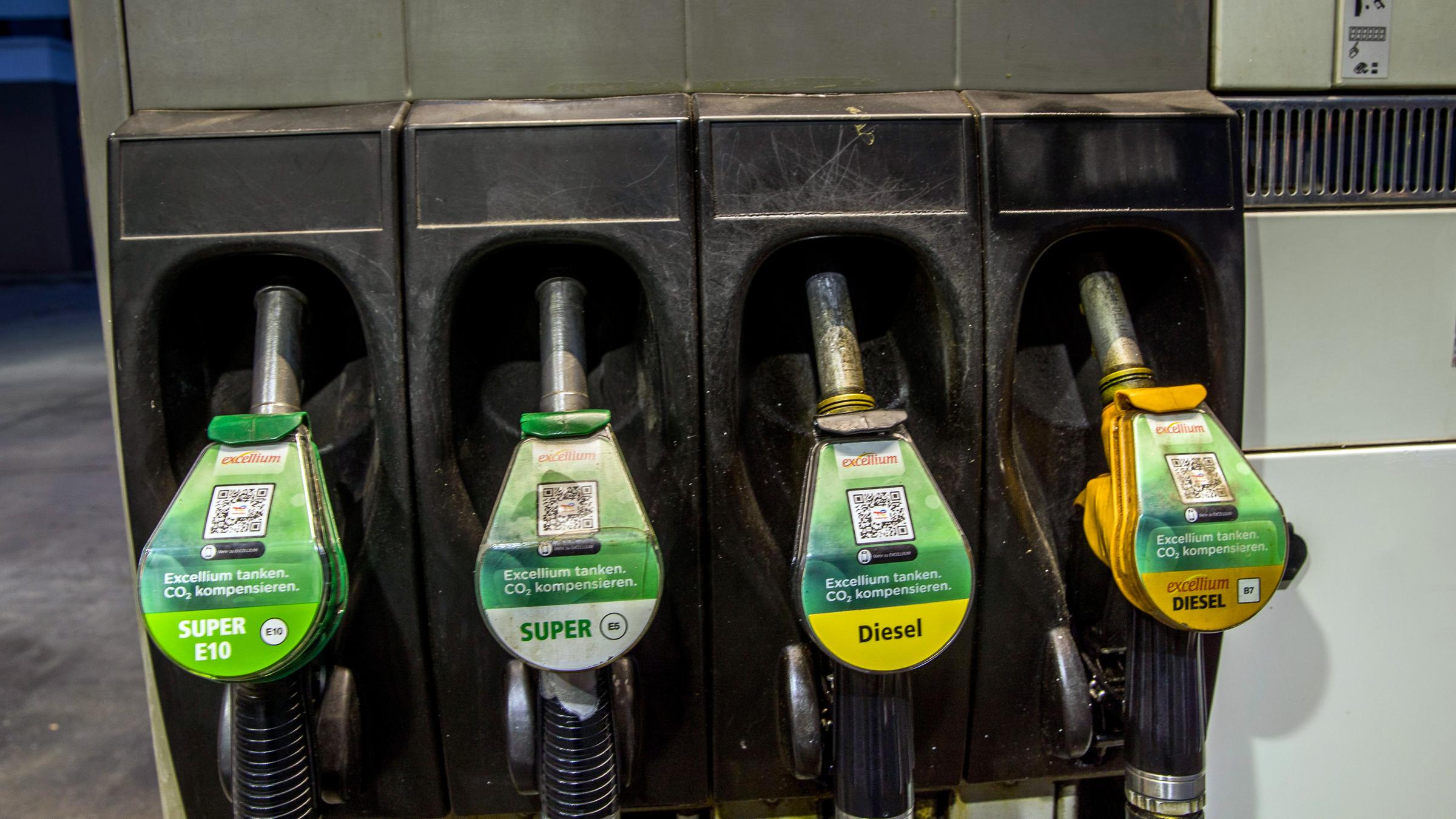 Zapfpistolen für die Kraftstoffe Benzin Super E10, Benzin Super E5, Diesel und excellium Diesel hängen an einer Zapfsäule Zapfpistolen für die Kraftstoffe Benzin Super E10, Benzin Super E5, Diesel und excellium Diesel hängen an einer Zapfsäule