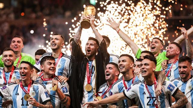 Das Foto zeigt die argentinische National-Mannschaft mit dem WM-Pokal, den Kapitan Messi hält.