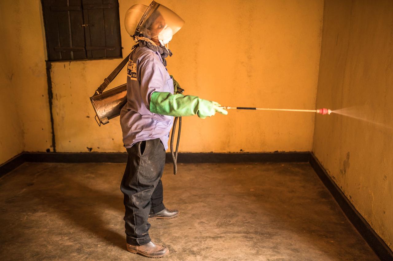 Ein Community Health Worker in Ruanda verteilt das Insektizidspray für Innenräume.