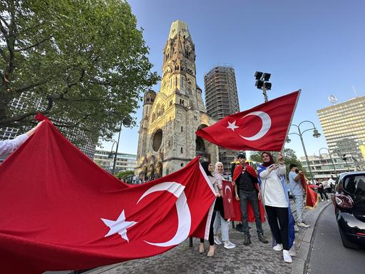 Türkische Wähler in Berlin schwenken die türkische Fahne und feiern den Sieg Erdogans.