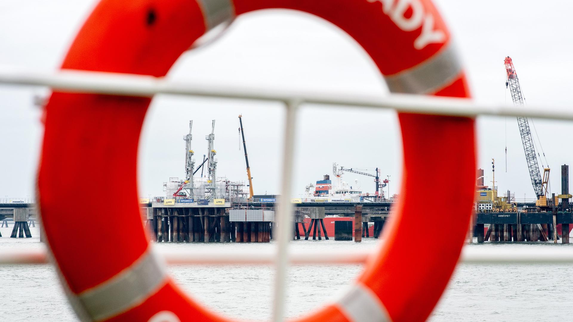 Technische Anlagen und ein Kran stehen auf dem Anleger für das LNG-Terminal in der Nordsee vor Wilhelmshaven. Der erste Anleger für Flüssigerdgas (LNG) in Deutschland ist fertiggestellt und am Dienstag eröffnet worden. In rund einem Monat soll ein beladenes Spezialschiff, eine sogenannte schwimmende Speicher- und Regasifizierungsanlage (FSRU), an dem Landungsplatz anlegen.