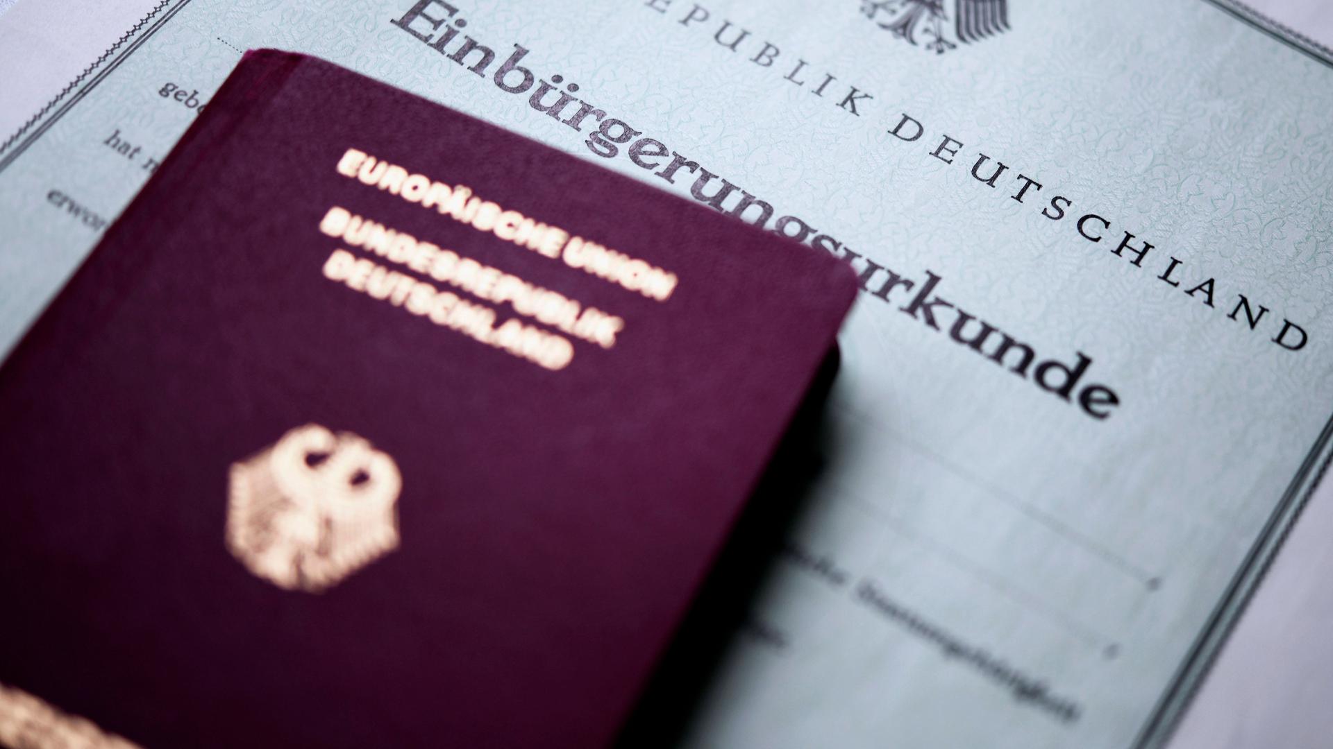 Eine deutsche Einbürgerungsurkunde und ein deutscher Pass.