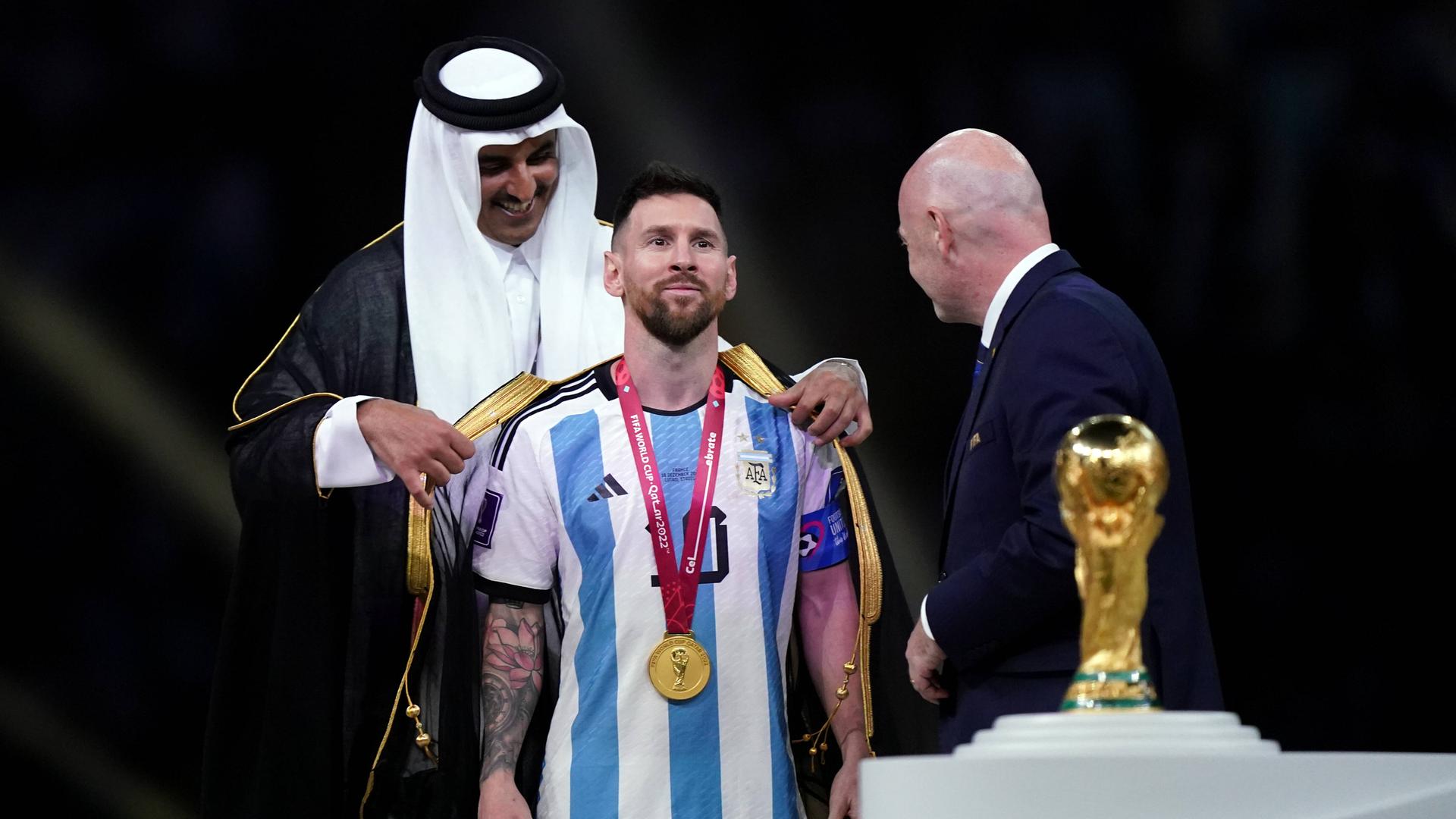 Der Emir von Katar überreicht Lionel Messi im Beisein von FIFA-Präsident Gianni Infantino einen Bischt. Der Emir von Katar überreicht Lionel Messi im Beisein von FIFA-Präsident Gianni Infantino einen Bischt.