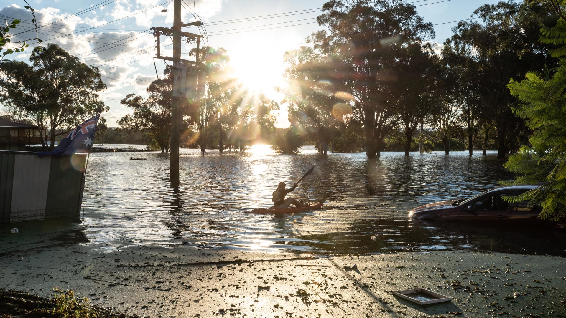 Ein Mädchen paddelt in einem Kanu durch die Fluten am 24. März 2021 in South Windsor Sydney, Australien. Ein Mädchen paddelt in einem Kanu durch die Fluten am 24. März 2021 in South Windsor Sydney, Australien.