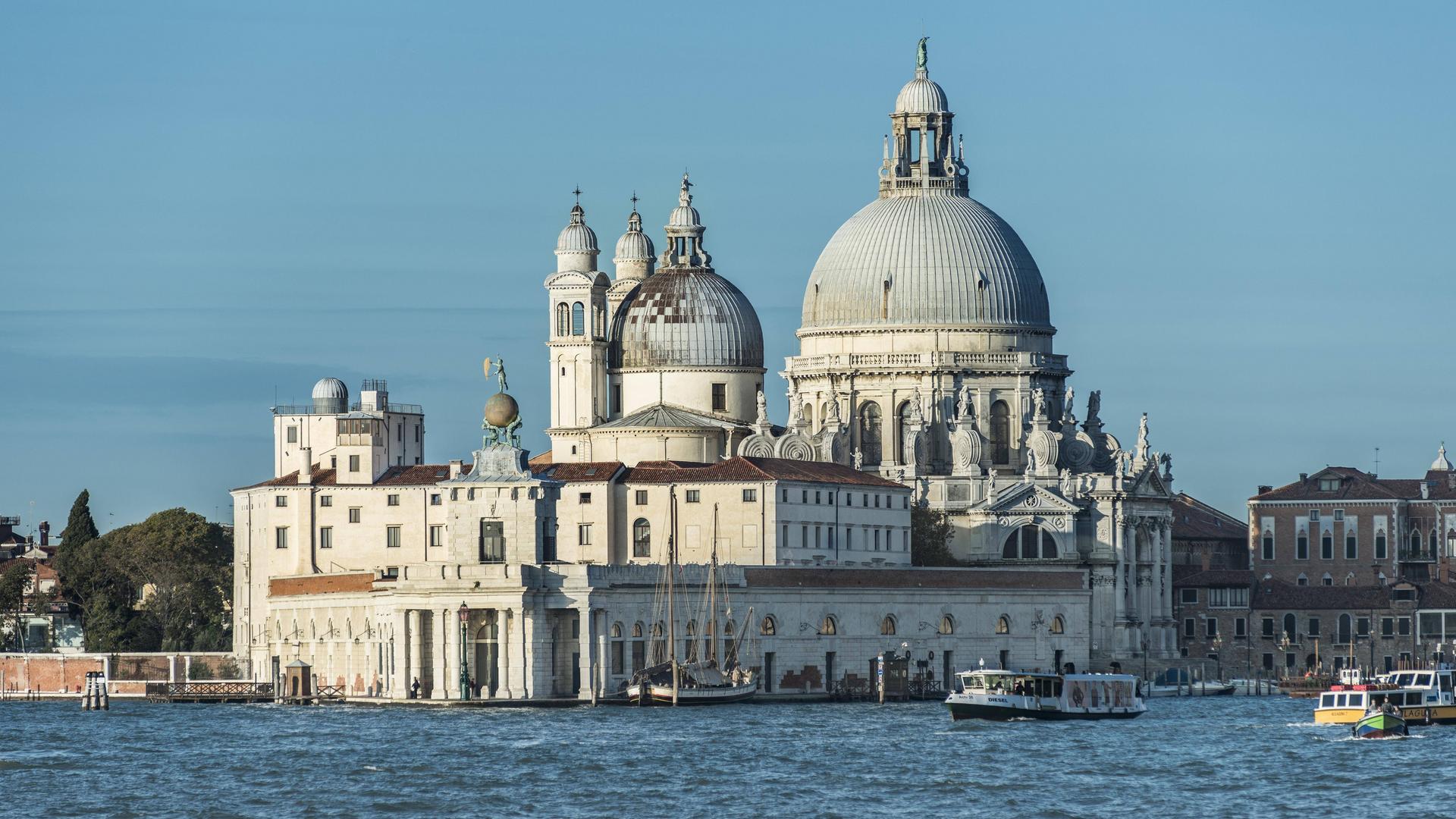 Wir sehen eine barocke Kirche, die an der Einfahrt zum Canal Grande in Venedig steht. Wir sehen eine barocke Kirche, die an der Einfahrt zum Canal Grande in Venedig steht.