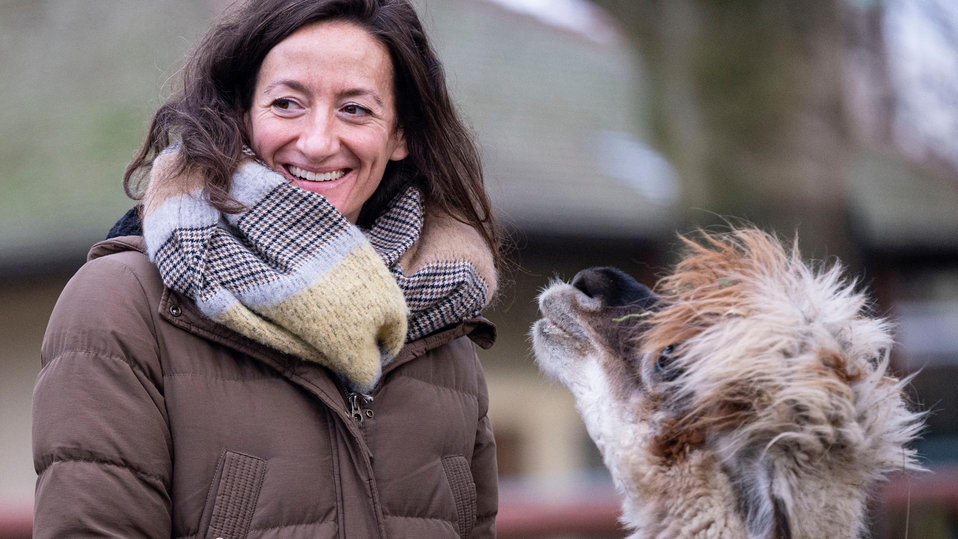 Das Bild zeigt die lächelnde Christina Geiger in einer Aussenaufnahme mit einem Zootier. Das Bild zeigt die lächelnde Christina Geiger in einer Aussenaufnahme mit einem Zootier.