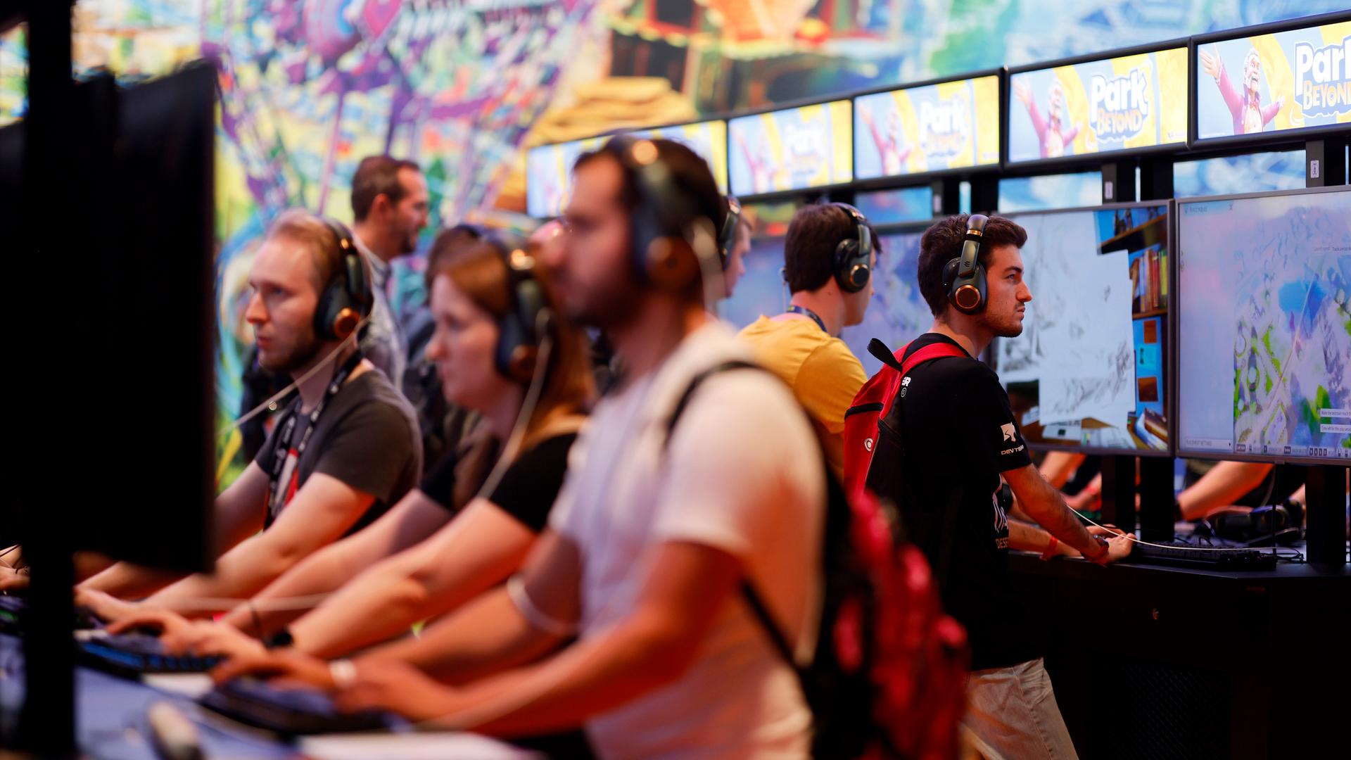 Menschen spielen auf der Gamescom am Computer Menschen spielen auf der Gamescom am Computer