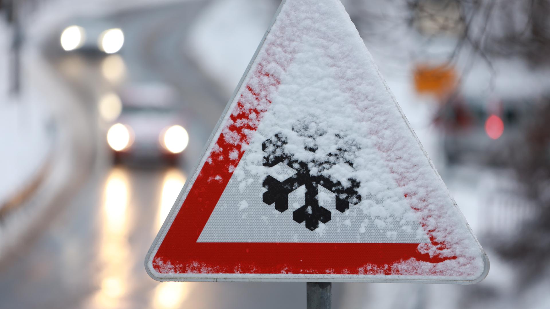 Ein Verkehrs-Zeichen mit einer Schnee-Flocke warnt vor Glätte.