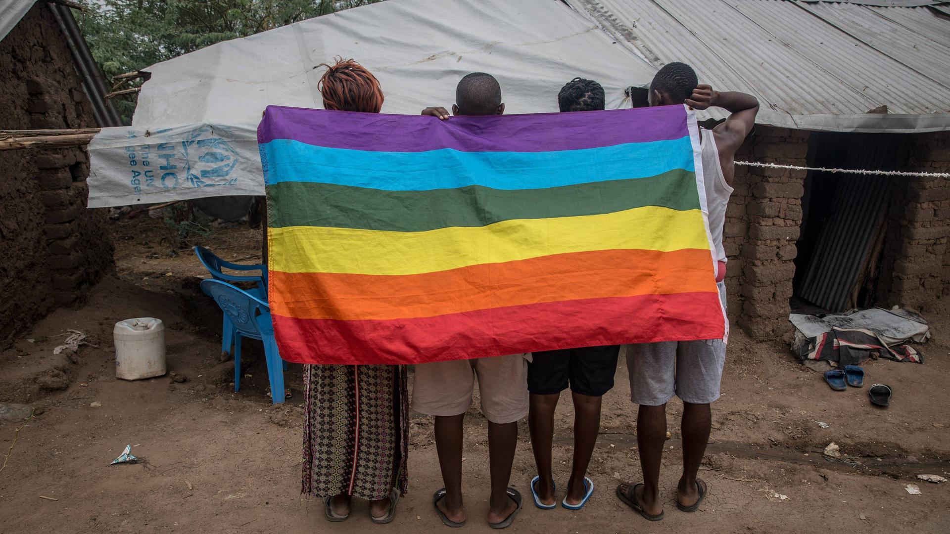 Das Foto zeigt Menschen aus Uganda, die nach Kenia geflüchtet sind. Sie halten eine Regen-Bogen-Fahne hoch. Das Foto zeigt Menschen aus Uganda, die nach Kenia geflüchtet sind. Sie halten eine Regen-Bogen-Fahne hoch.