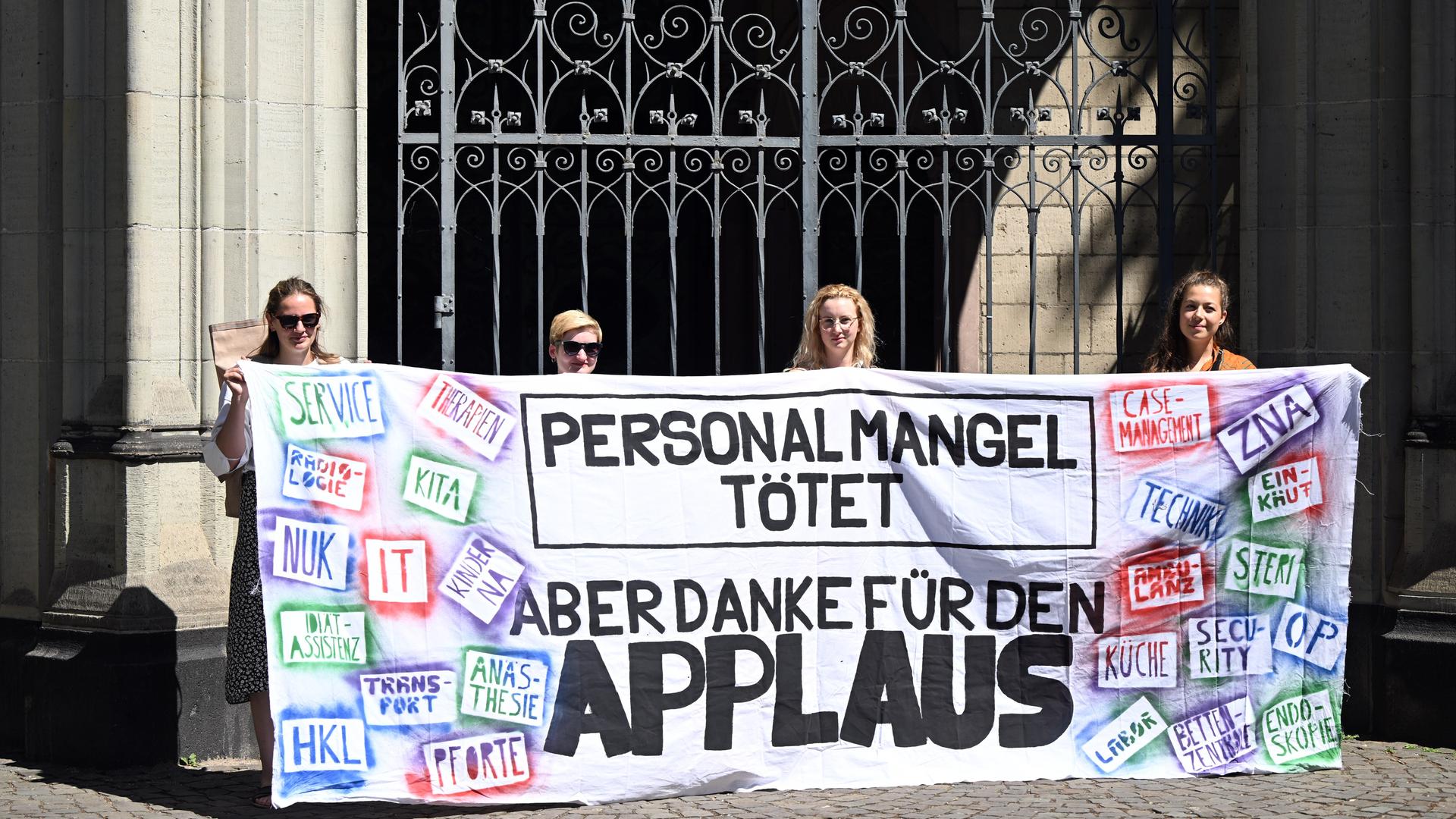 Streikende Pflegekräfte von Unikliniken halten ein Transparent mit der Aufschrift "Personalmangel tötet - Aber danke für den Applaus" Streikende Pflegekräfte von Unikliniken halten ein Transparent mit der Aufschrift "Personalmangel tötet - Aber danke für den Applaus"