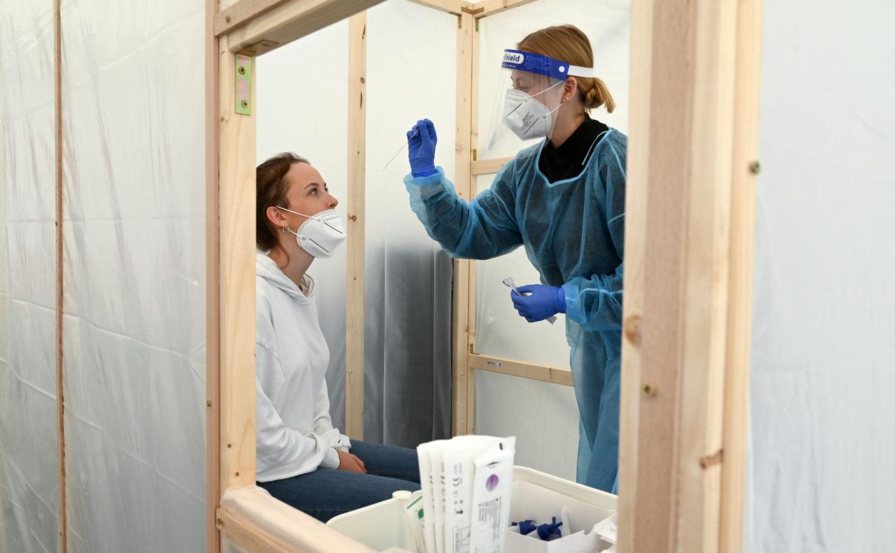 Eine Frau lässt sich in einer provisorischen Holzkabine auf den Coronavirus testen. Eine Frau lässt sich in einer provisorischen Holzkabine auf den Coronavirus testen.
