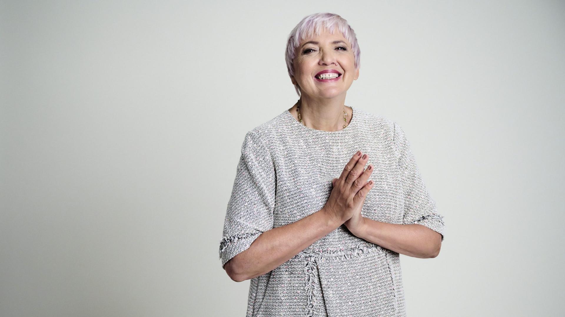 Claudia Roth in silberfarbenem Kostüm lacht mit knalligem Lippenstift in die Kamera. Claudia Roth in silberfarbenem Kostüm lacht mit knalligem Lippenstift in die Kamera.