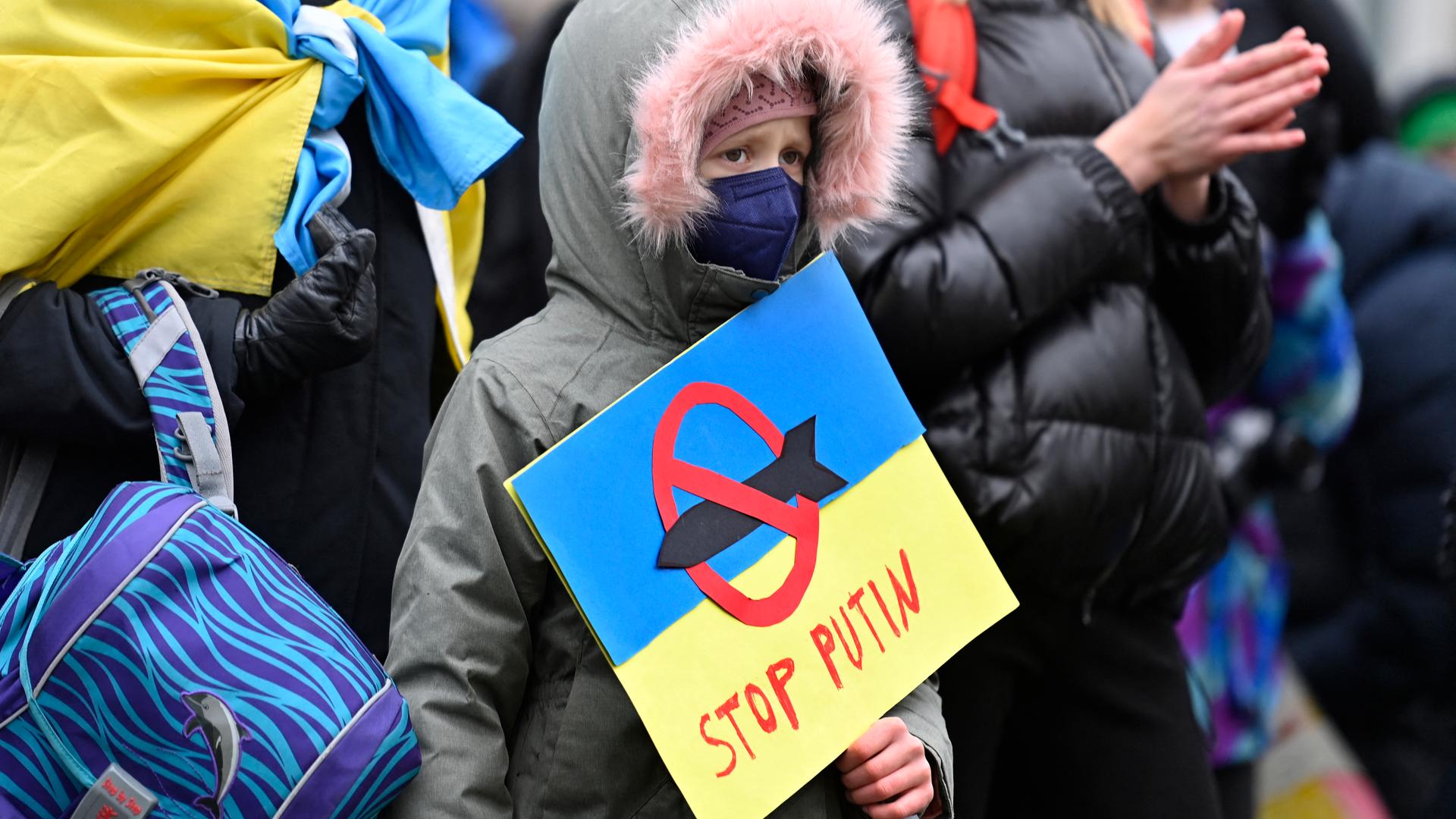 Ein junger Demonstrant hält ein Plakat in den Farben der ukrainischen Flagge, mit der Aufschrift „Stop Putin“ und der Darstellung einer Rakete, die mit einem roten Verbotszeichen versehen ist, in seinen Händen. Ein junger Demonstrant hält ein Plakat in den Farben der ukrainischen Flagge, mit der Aufschrift „Stop Putin“ und der Darstellung einer Rakete, die mit einem roten Verbotszeichen versehen ist, in seinen Händen.