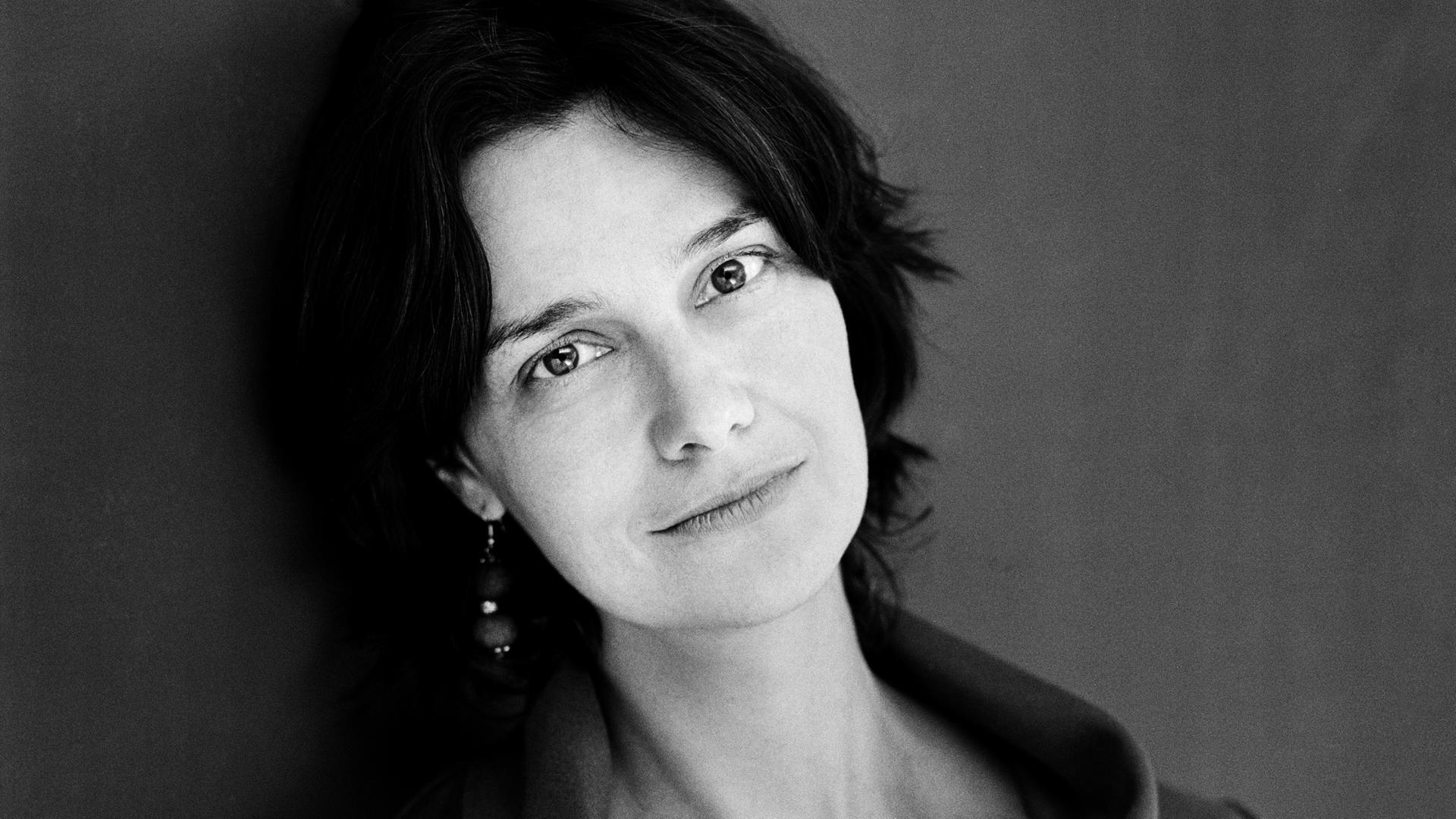 Schwarz-Weiß-Porträt der Schriftstellerin Katja Petrowskaja, die direkt in die Kamera blickt. 