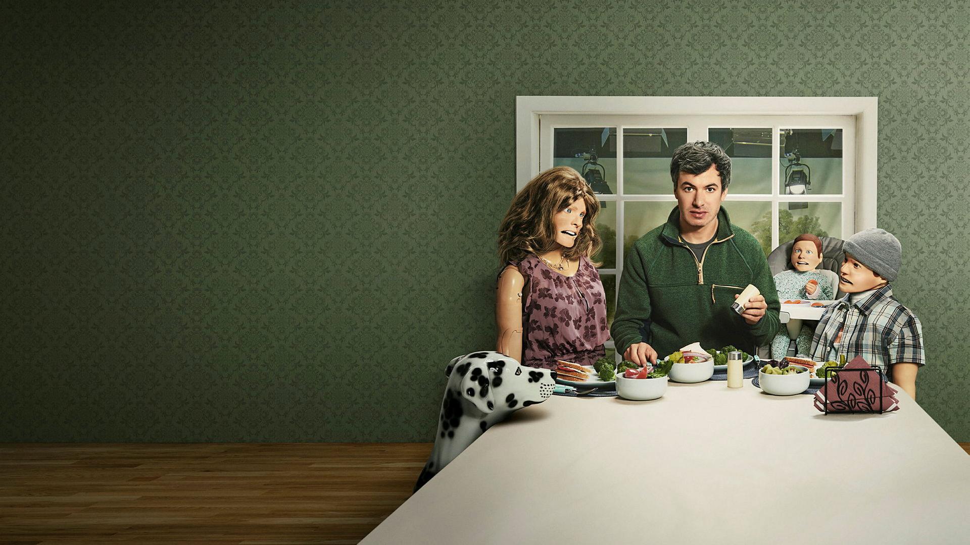 Der Hauptdarsteller der Comedy Serie "The Rehearsal" sitzt mit menschlichen Puppen an einem Esstisch. Der Hauptdarsteller der Comedy Serie "The Rehearsal" sitzt mit menschlichen Puppen an einem Esstisch.