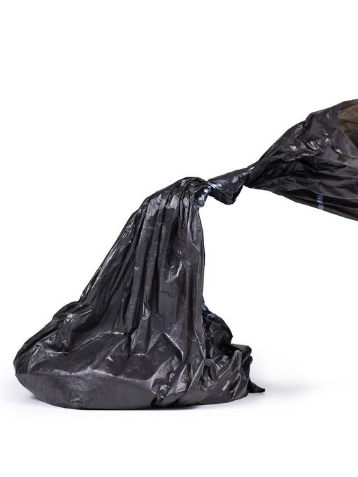 Ein schwarzer Plastikhundekotbeutel auf weißem Hintergrund.