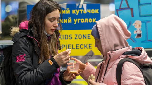 Eine ukrainische Mutter steht mit ihrer Tochter am Berliner Hauptbahnhof