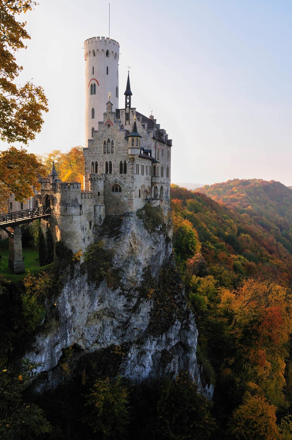 Das Romantik-Schloss Lichtenstein auf der Schwäbischen Alb. Ein Schloss mit Turm und Zinnen auf einem Felsen. Im Hintergrund sind die dicht bewachsenen Hügel der Schwäbischen Alb zu sehen. Das Romantik-Schloss Lichtenstein auf der Schwäbischen Alb. Ein Schloss mit Turm und Zinnen auf einem Felsen. Im Hintergrund sind die dicht bewachsenen Hügel der Schwäbischen Alb zu sehen.