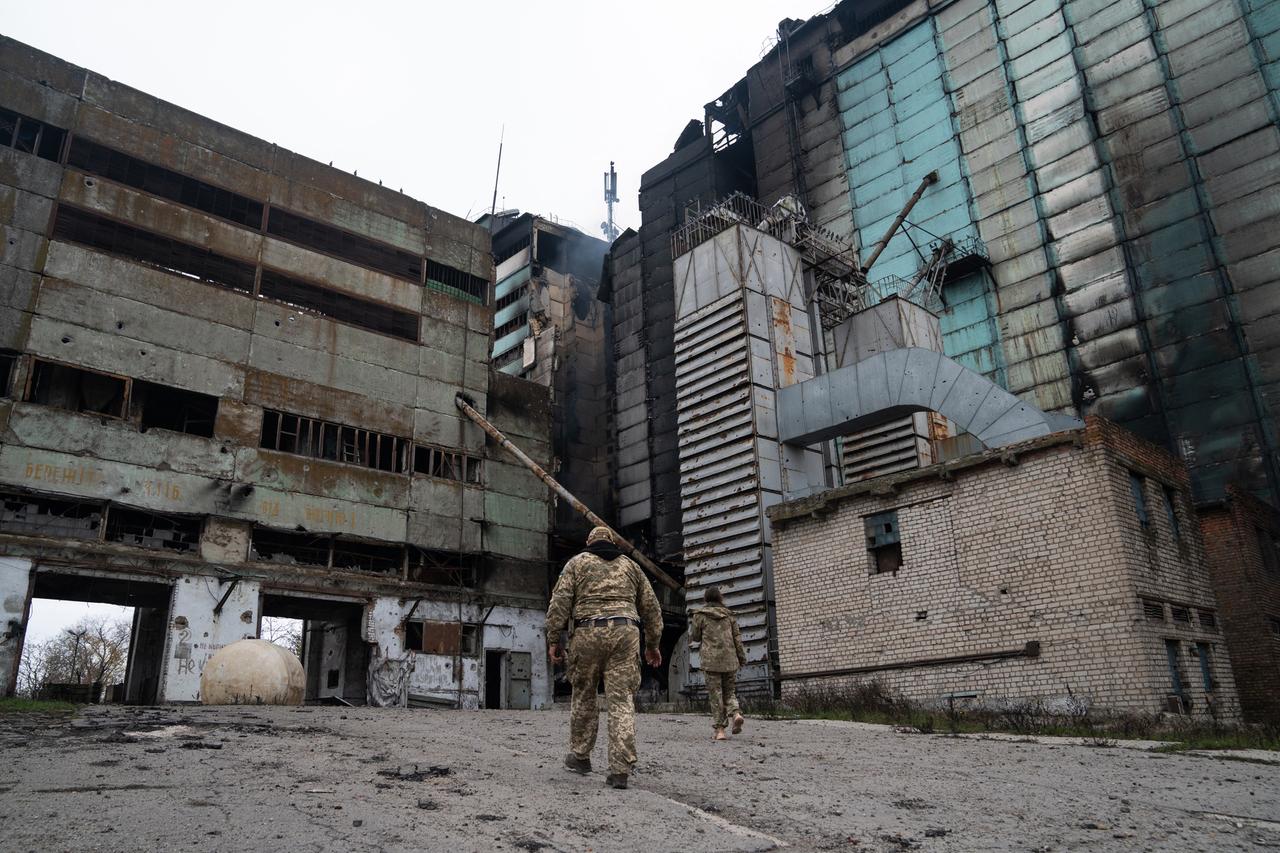 Ukrainische Soldaten laufen auf ein ausgebranntes Industriegebäude im Gebiet Cherson zu. In der Mitte raucht es noch. Ukrainische Soldaten laufen auf ein ausgebranntes Industriegebäude im Gebiet Cherson zu. In der Mitte raucht es noch.
