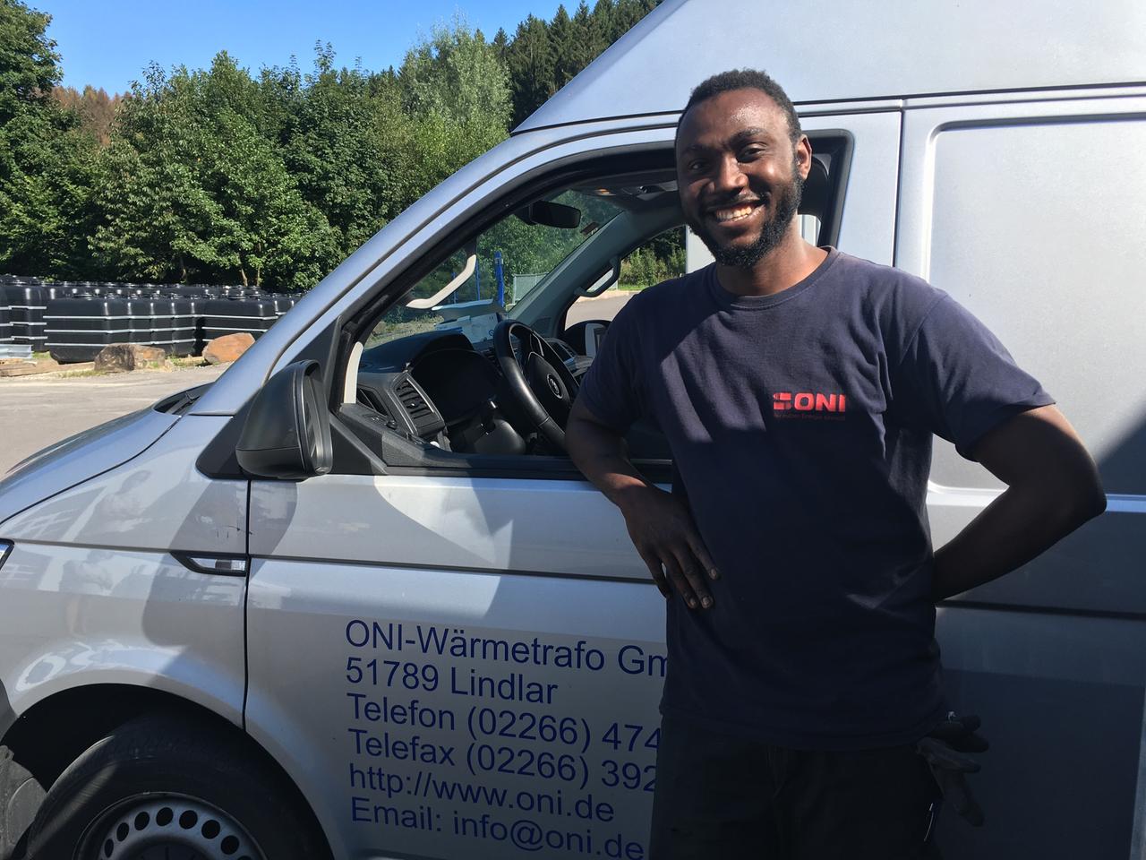 Ismael Fernandez steht vor einem Transporter der Firma ONI Ismael Fernandez steht vor einem Transporter der Firma ONI
