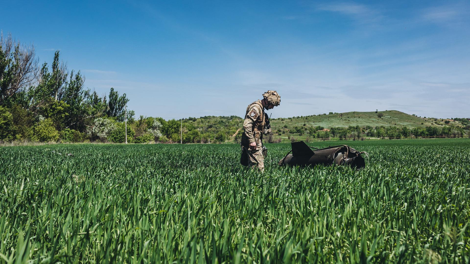 Ein ukrainischer Soldat betrachtet eine russische Rakete auf einem Feld in Soledar Ein ukrainischer Soldat betrachtet eine russische Rakete auf einem Feld in Soledar