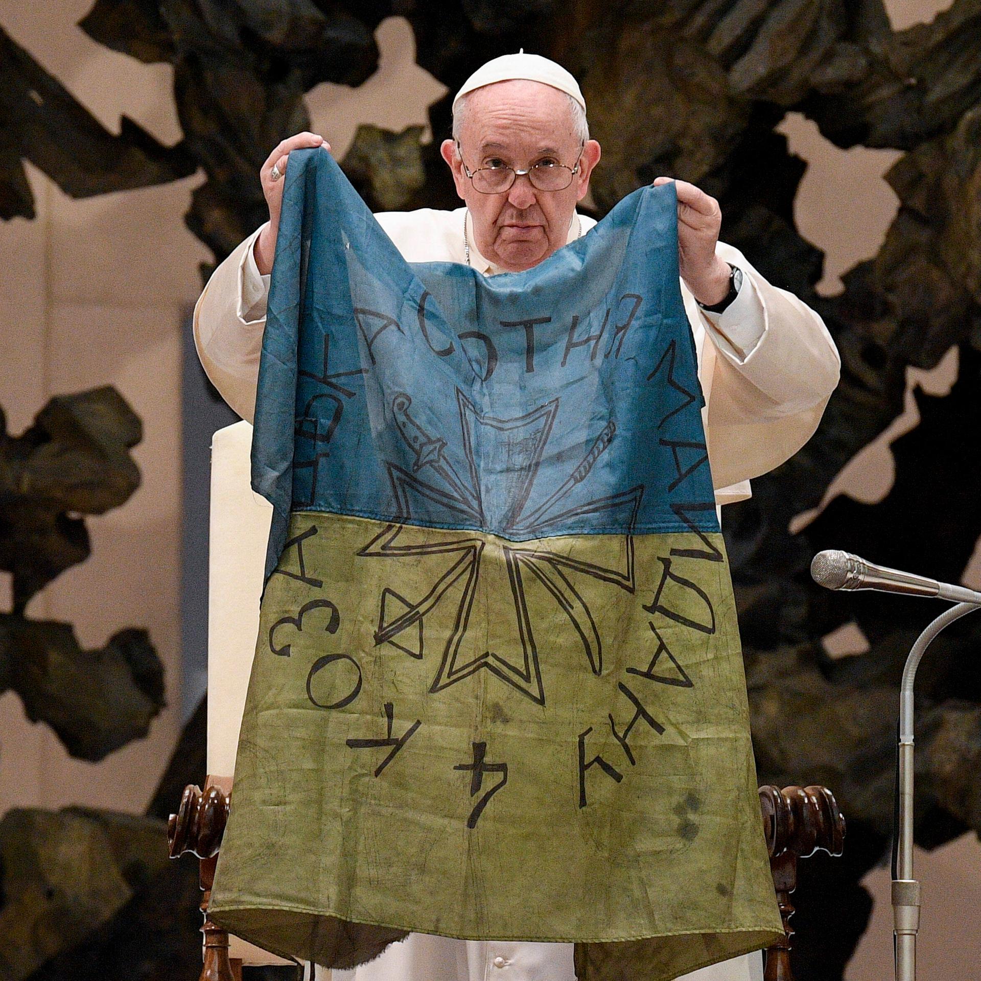 Papst Franziskus hält während seiner wöchentlichen Generalaudienz eine ukrainische Flagge hoch, die er nach seinen Aussagen aus der ukrainischen Stadt Butscha stammt. (imago 0154767020h)