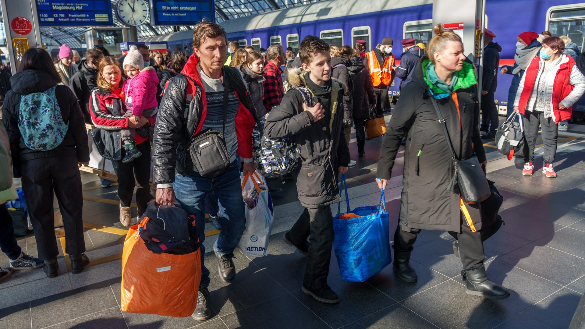 Ukrainische Flüchtlinge kommen am Berliner Hauptbahnhof an. Eine Familie geht mit Gepäck den Bahnsteig entlang. Ukrainische Flüchtlinge kommen am Berliner Hauptbahnhof an. Eine Familie geht mit Gepäck den Bahnsteig entlang.