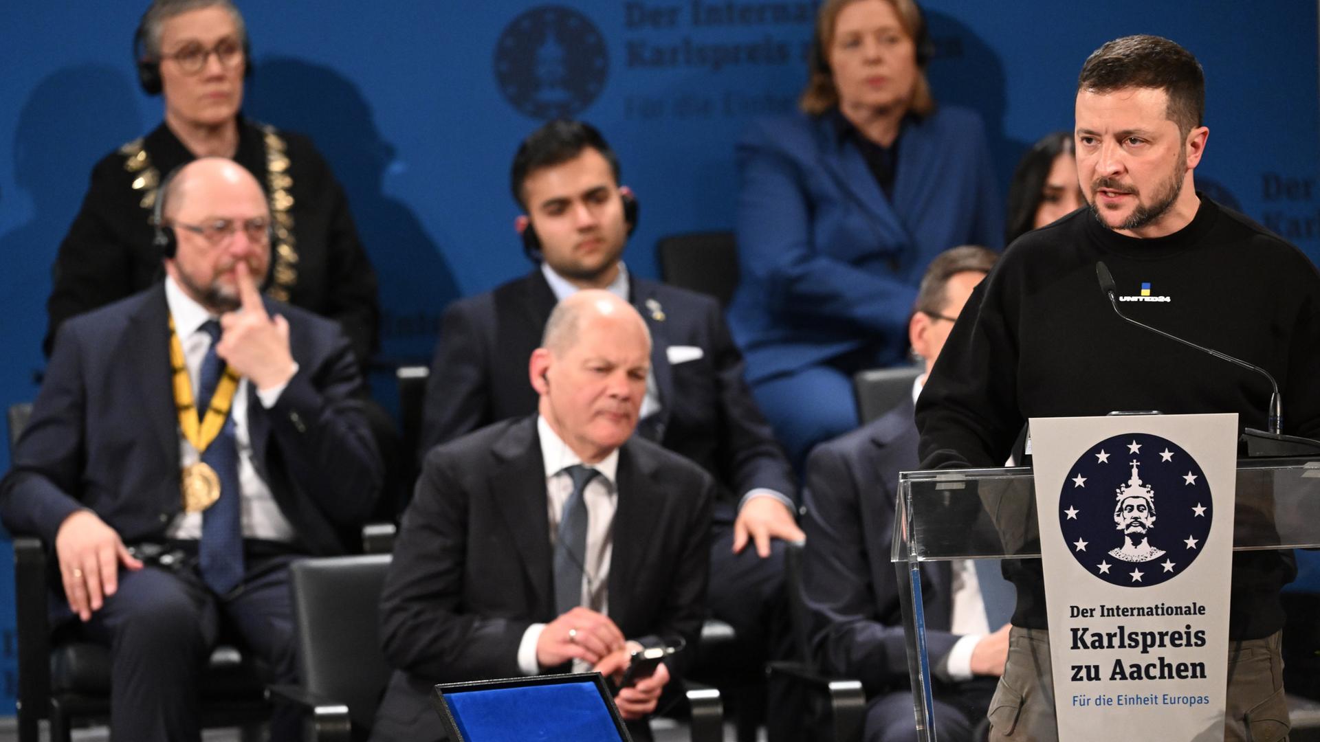 Der ukrainische Präsident und Preisträger Wolodymyr Selenskyj spricht bei der Verleihung des Karlspreises für Verdienste um die Einheit Europas im Krönungssaal in Aachen. Der ukrainische Präsident und Preisträger Wolodymyr Selenskyj spricht bei der Verleihung des Karlspreises für Verdienste um die Einheit Europas im Krönungssaal in Aachen.