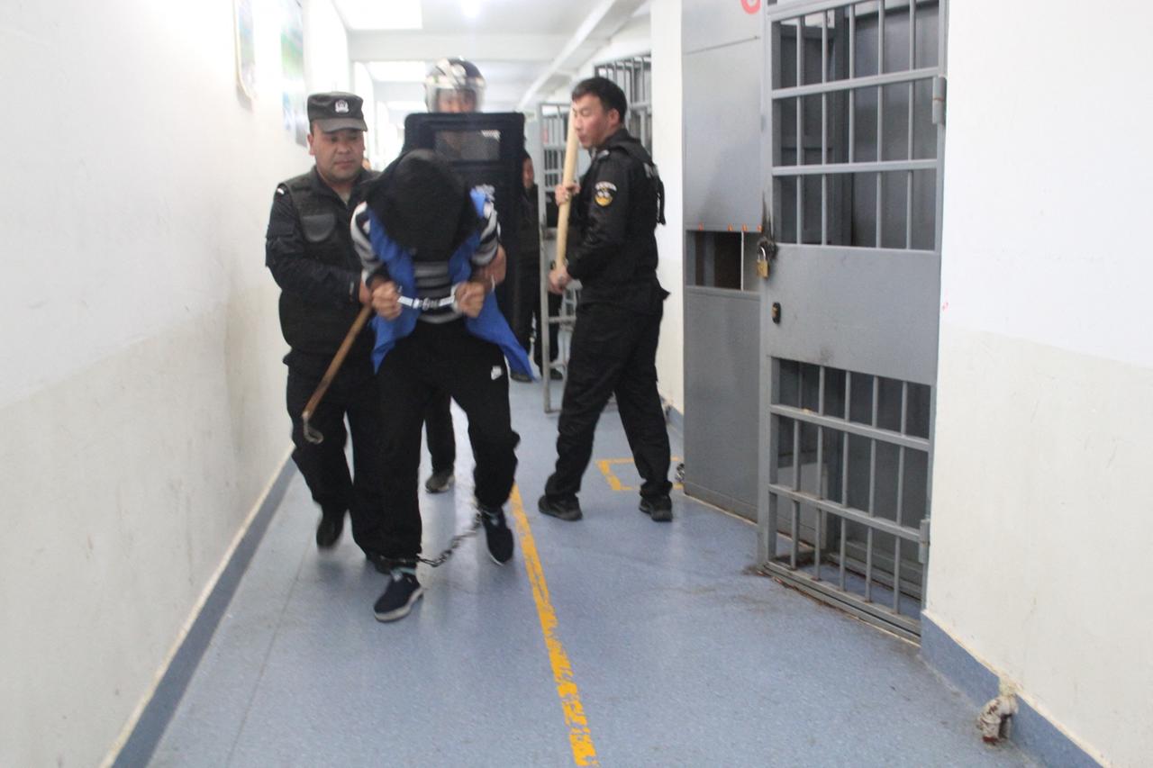Ein an Händen und Füßen gefesselter Mann in einem Zellentrakt, Bild aus den geleakten "Xinjiang Police Files", aufgenommen im Februar 2018 Ein an Händen und Füßen gefesselter Mann in einem Zellentrakt, Bild aus den geleakten "Xinjiang Police Files", aufgenommen im Februar 2018
