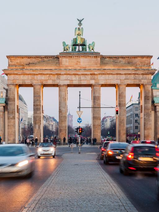 Frontalaufnahme vom Brandenburger Tor. Davor lange Autoschlangen.
