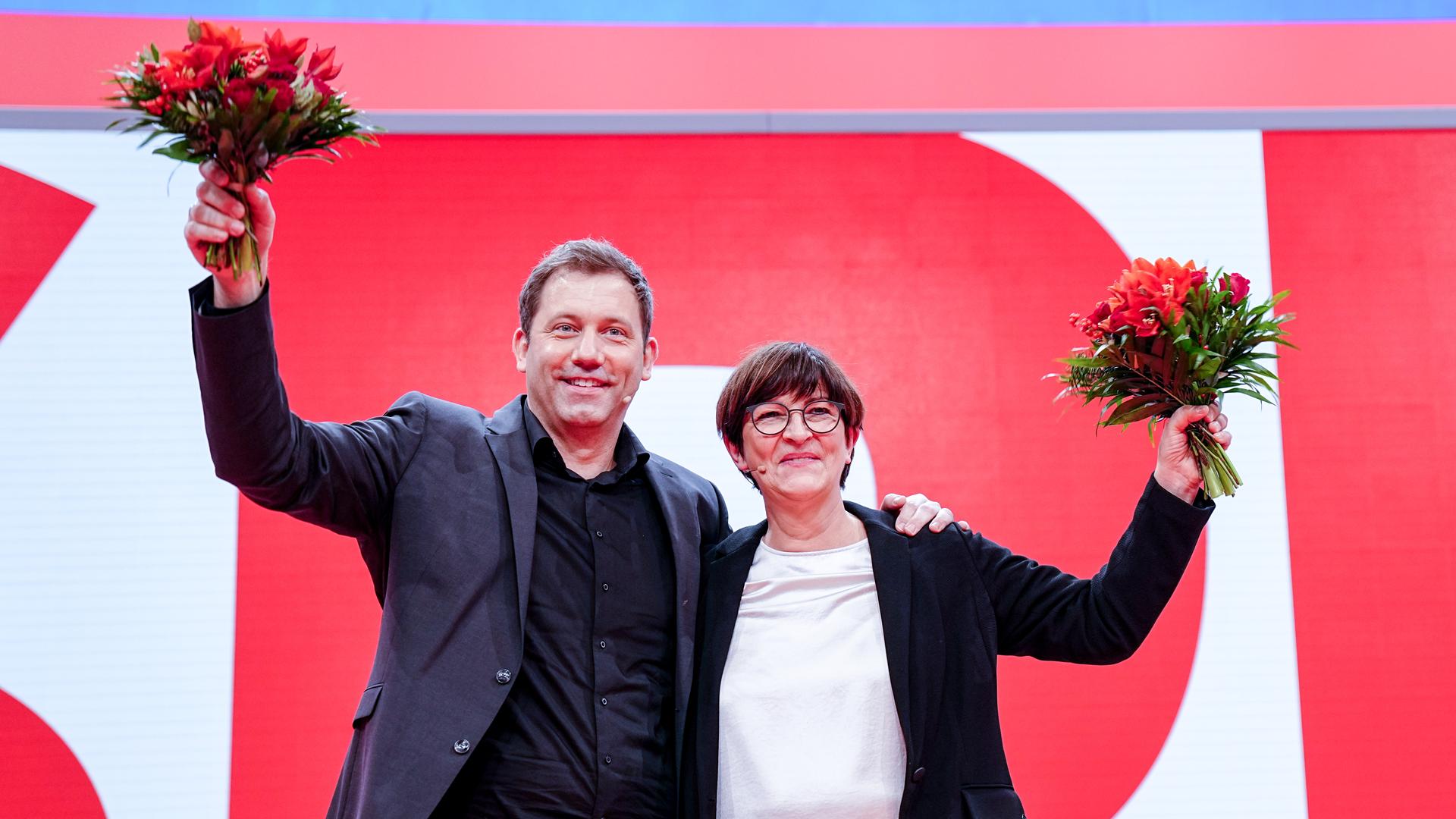 Lars Klingbeil, neugewählter SPD-Parteivorsitzender, und Saskia Esken, neugewählte SPD-Parteivorsitzende, winken mit Blumen beim Bundesparteitag ihrer Partei. Lars Klingbeil, neugewählter SPD-Parteivorsitzender, und Saskia Esken, neugewählte SPD-Parteivorsitzende, winken mit Blumen beim Bundesparteitag ihrer Partei.