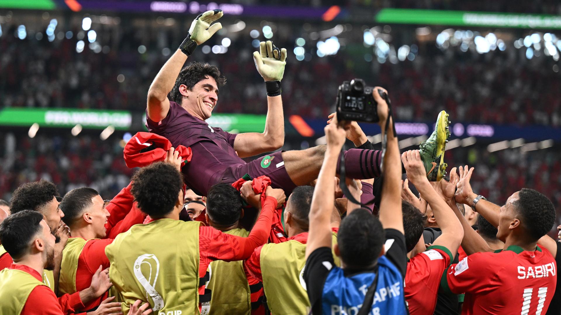 Marokkos Torwart Bono und seine Mitspieler jubeln nach dem Sieg im Elfmeterschiessen gegen Spanien bei der Fußball-WM 2022 in Katar. Die Spieler werfen ihren Torwart vor Freude in die Luft und lassen ihn hochleben
